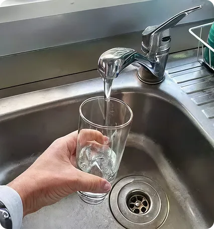 Glass under running tap