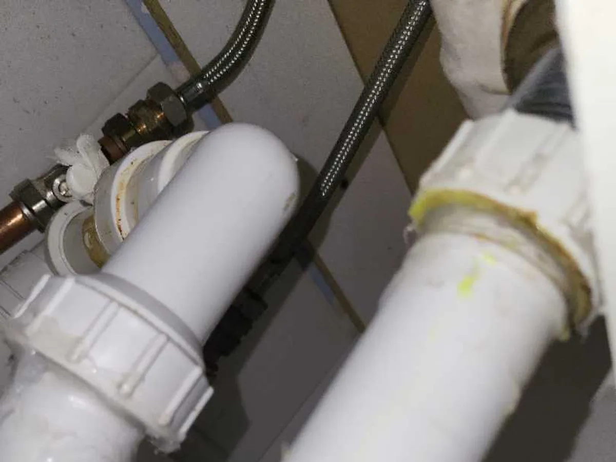 Inline water filter housing connected to copper pipe and braided flexi hose during an internal mains leak detection at a property in WF8