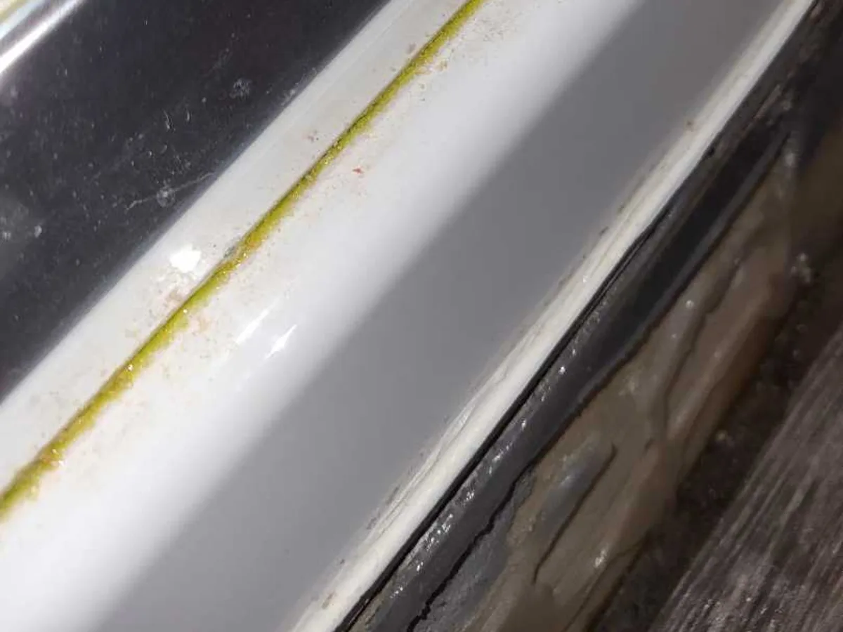 Yellow staining along the rim of a bath where the seal meets the wall during an internal mains leak detection survey at a property in WF8