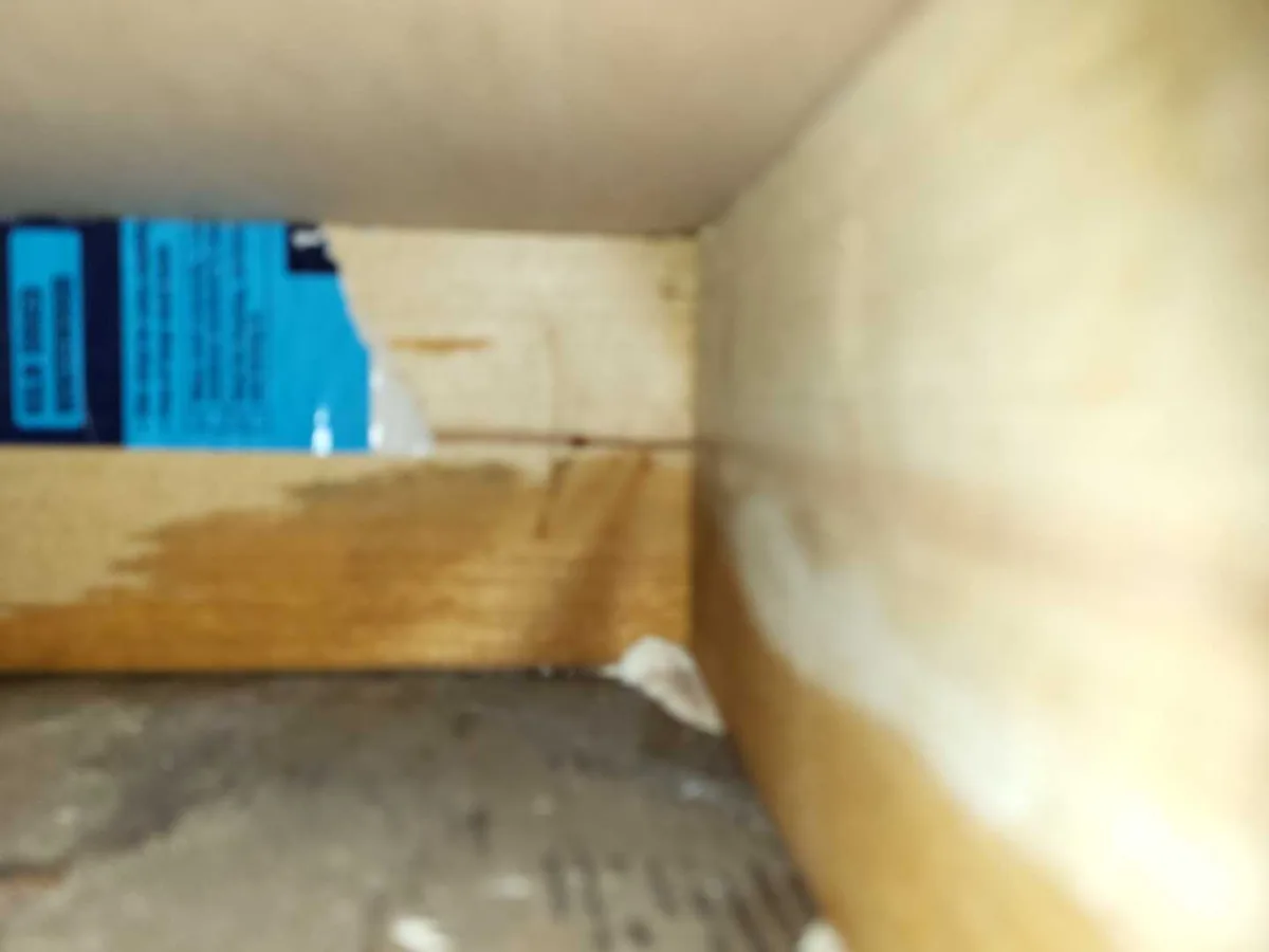 Water staining on plywood shelf inside an under-sink void during an internal mains leak detection survey at a property in WF8