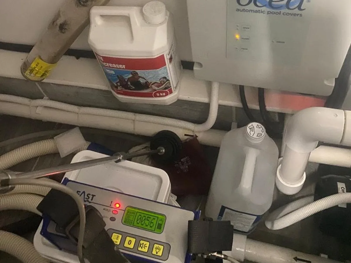 CAST pool controller displaying reading 0856 alongside pool chemical containers during a swimming pool leak detection survey at a property in Harrow