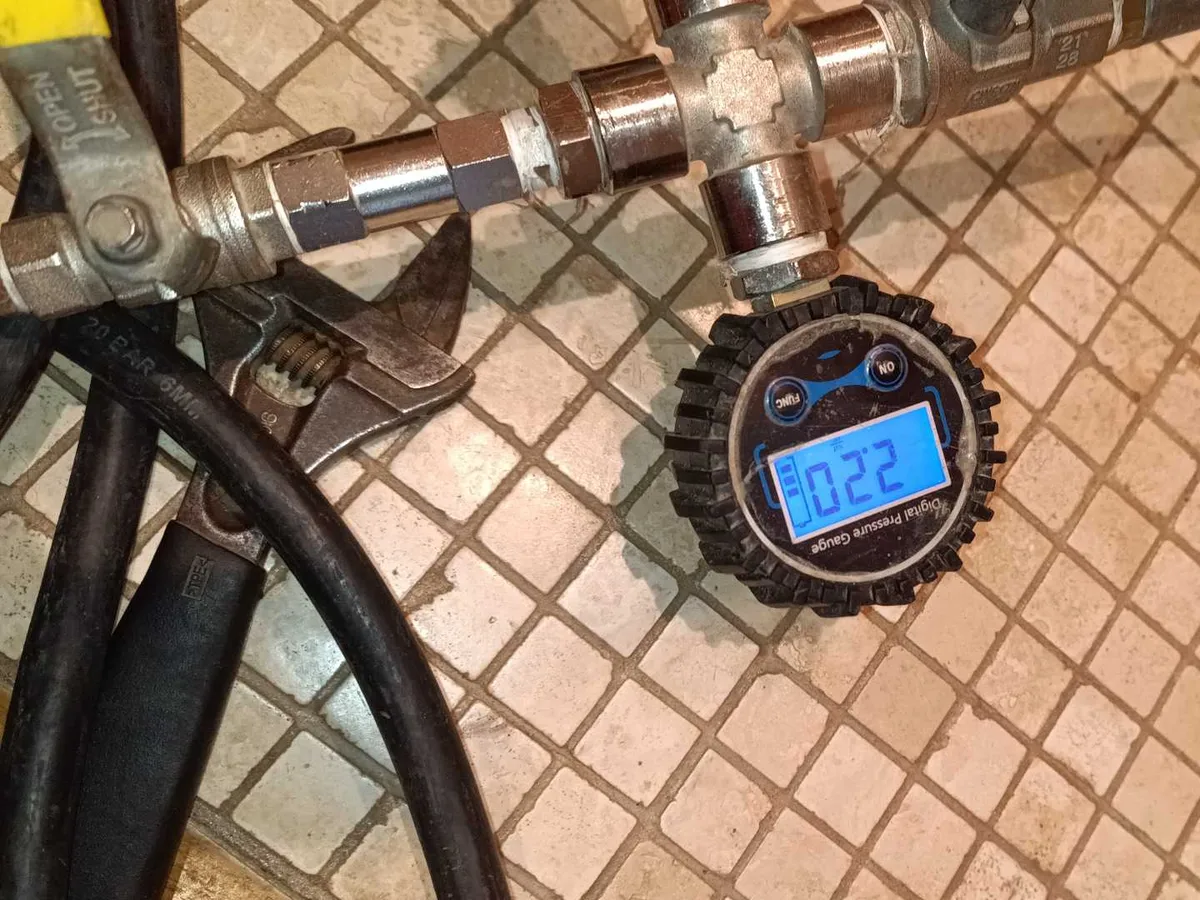 Digital pressure gauge reading 0.22 bar connected to central heating pipework during a leak detection survey at a property in BA3
