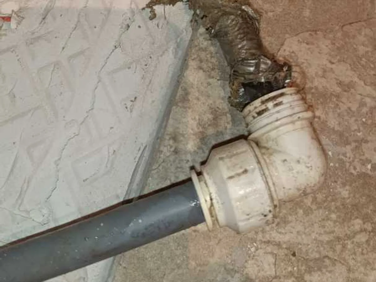 PVC elbow pipe fitting connecting to a wall penetration during a central heating leak detection survey at a property in BA3