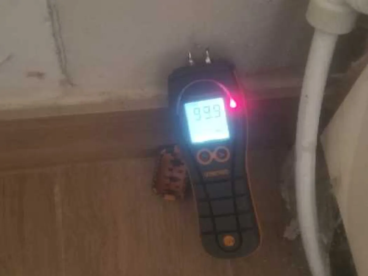 moisture meter showing maximum reading at skirting board during leak detection survey
