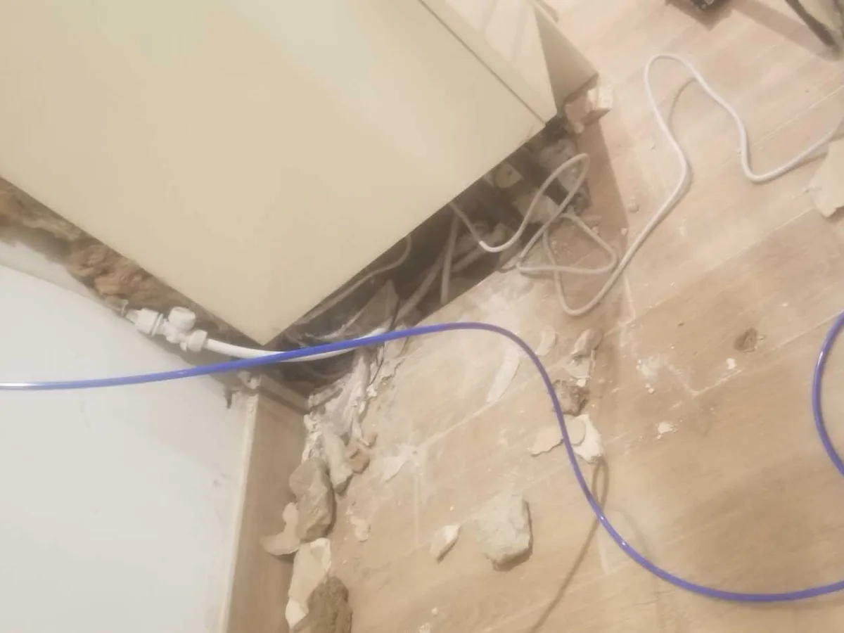 new plastic heating pipework routed beneath kitchen floor as repair in progress