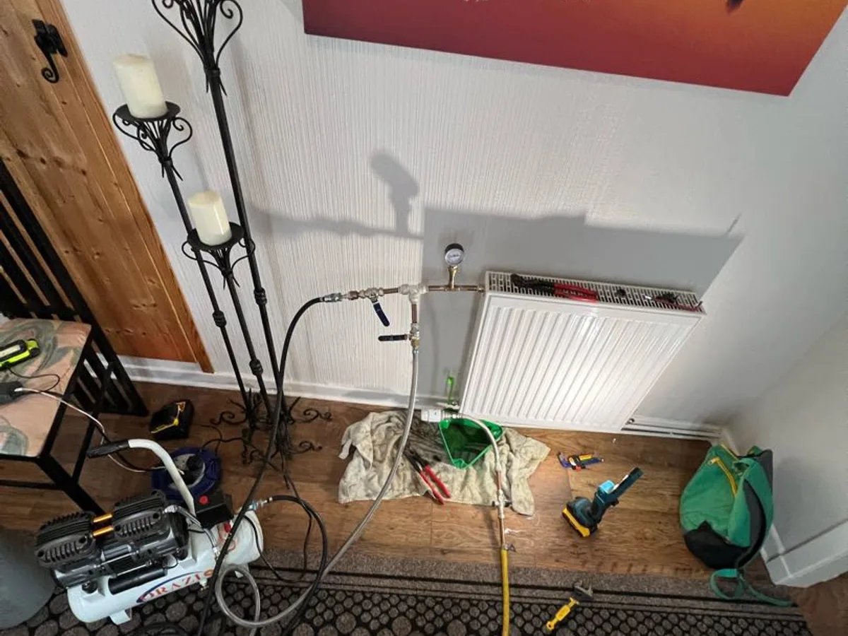 pressure testing equipment connected to bedroom radiator during leak detection