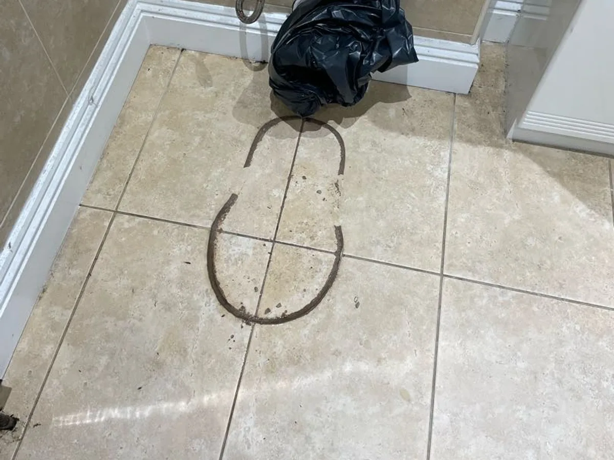 leak located at bathroom floor after toilet removed showing dirty ring stain on tiles