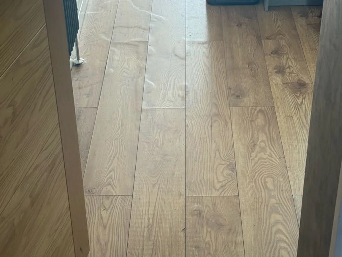 warped and water-damaged laminate flooring in kitchen before works started