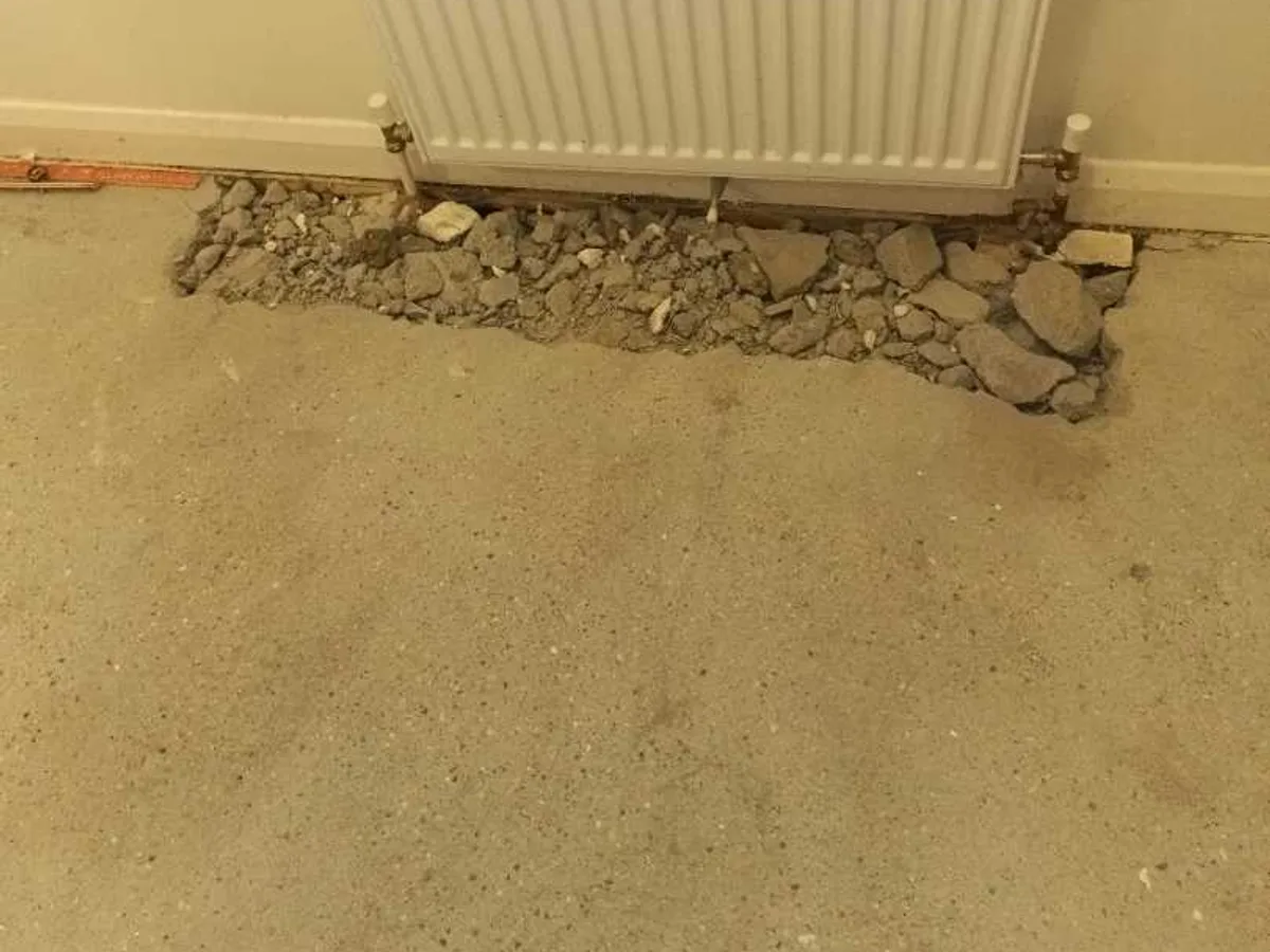 hallway radiator with backfilled concrete floor channel after works completed