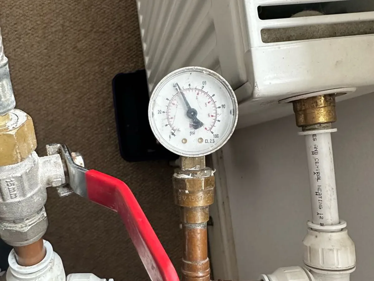 pressure gauge and isolation valve on radiator manifold pipework during leak detection