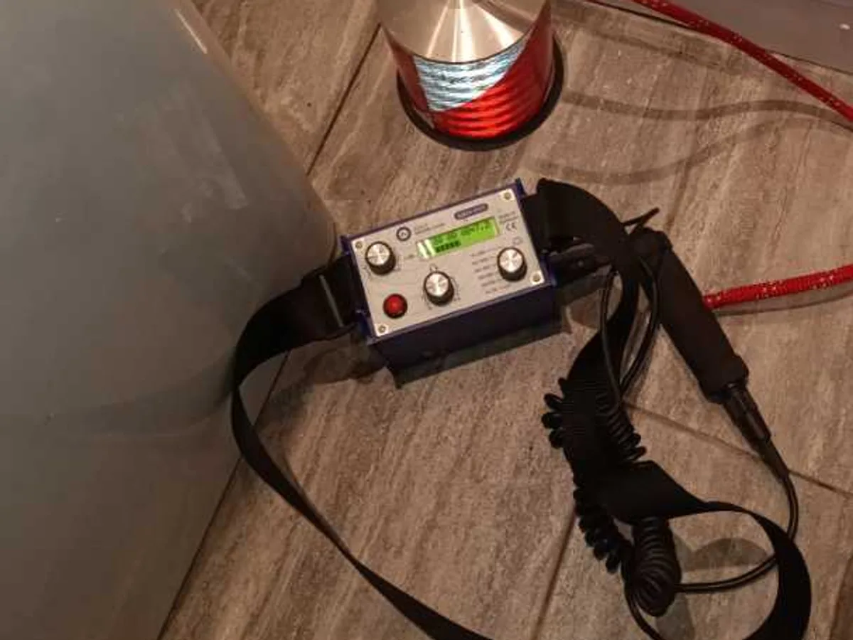 acoustic listening device on tiled floor of garage bathroom during leak detection survey