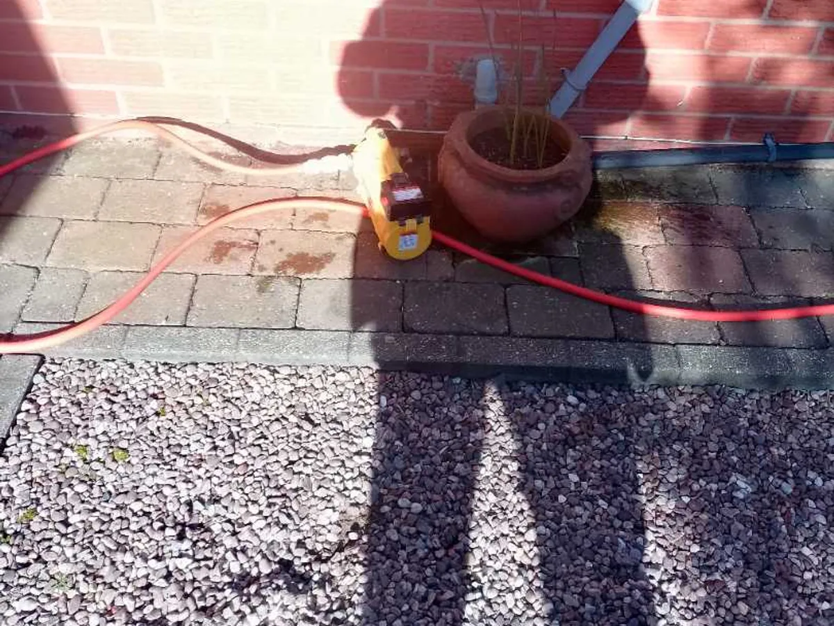 yellow tracer gas pump with hoses connected at external wall during leak detection survey