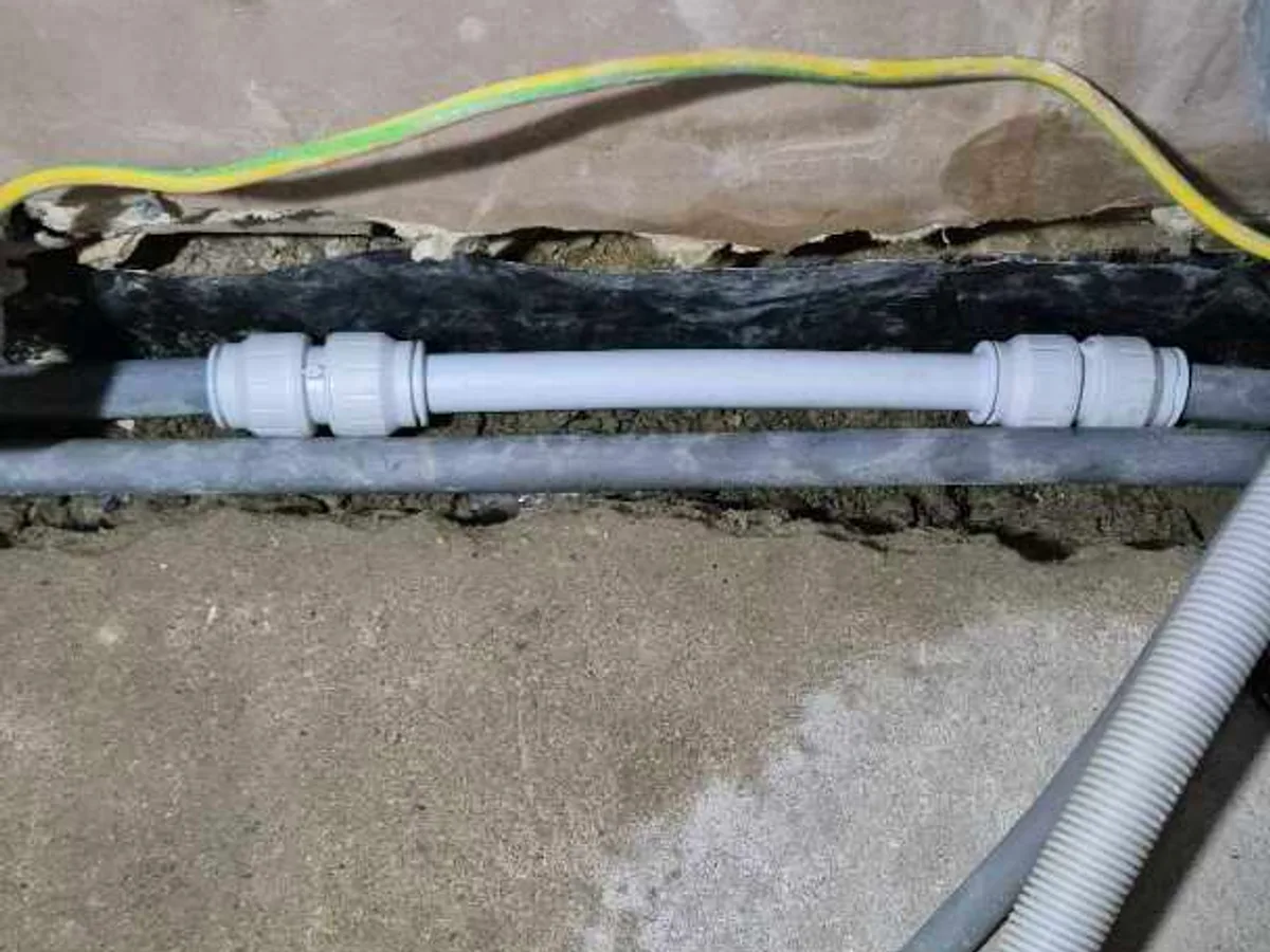 new section of 22mm plastic heating pipe with push-fit couplings repair completed in screed channel