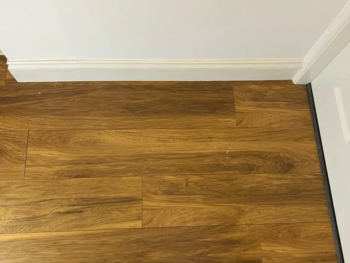 timber laminate hallway floor viewed from above during leak detection investigation before boards lifted