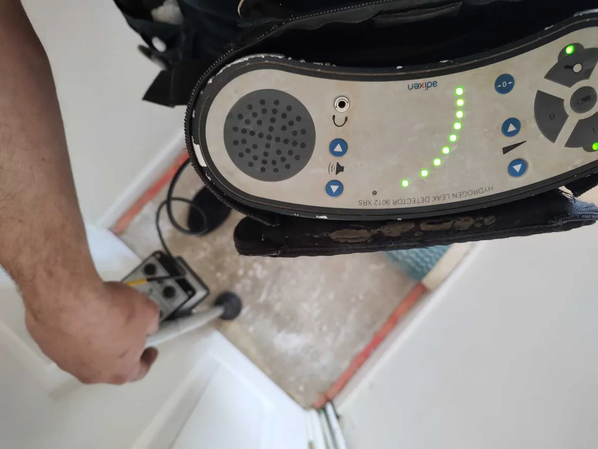 hydrogen tracer gas detector probe scanning bathroom floor tiles during leak detection