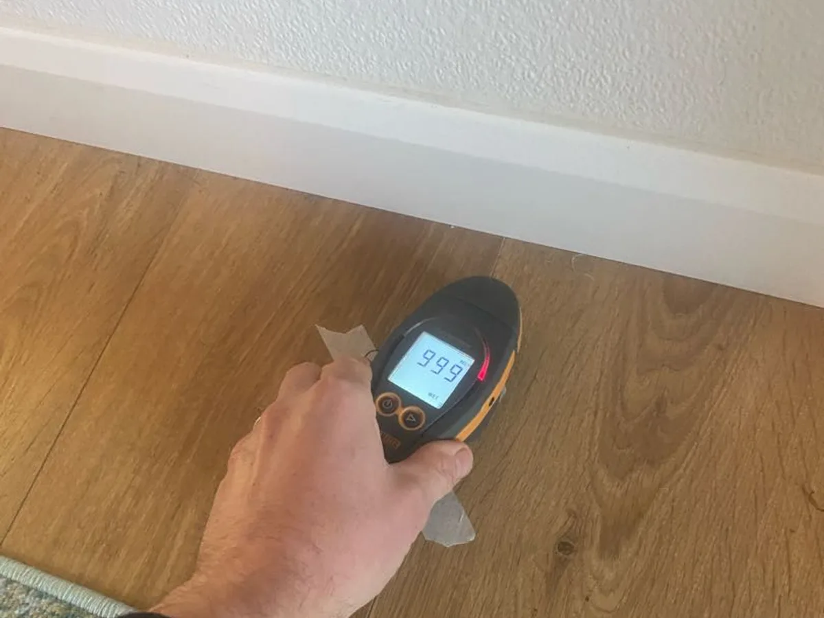 moisture meter reading 999 on laminate floor during leak detection investigation