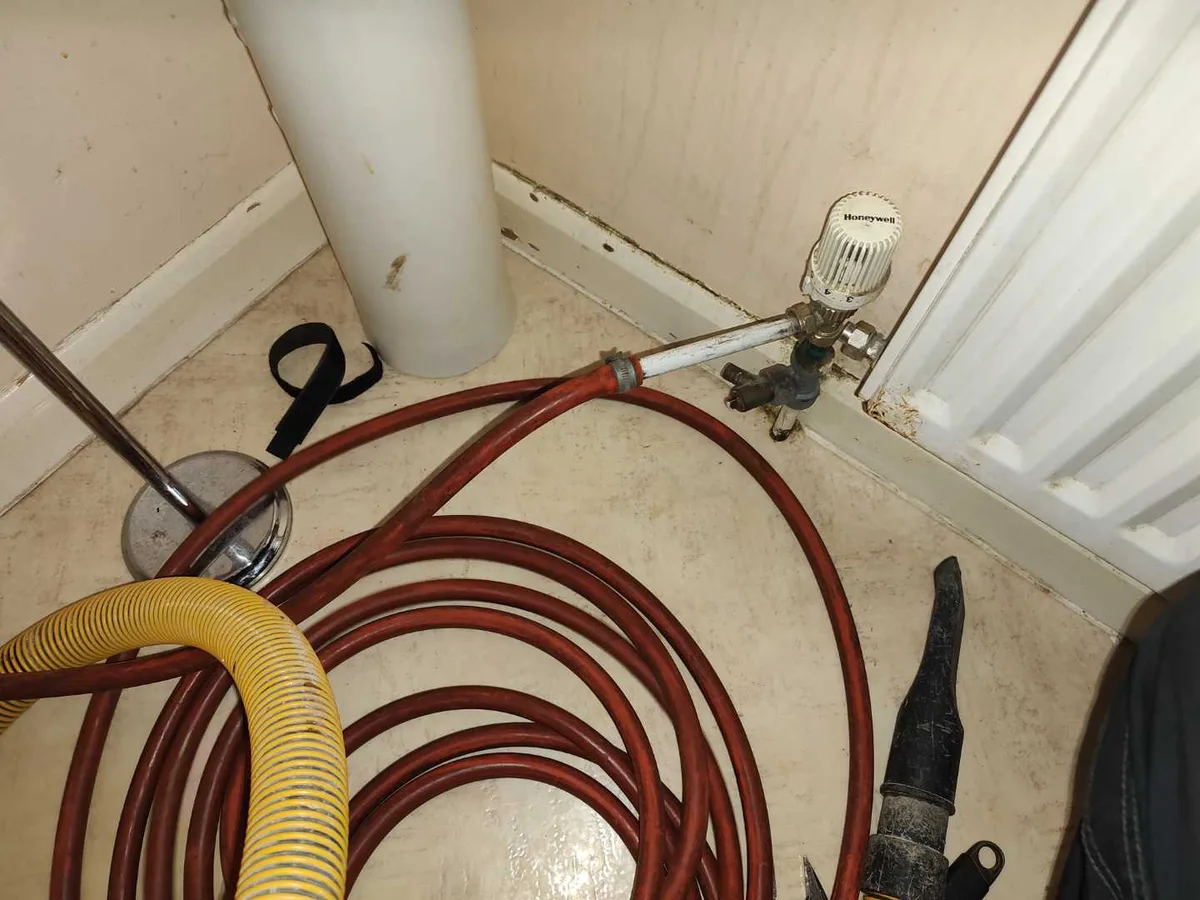 drain-down hoses connected to radiator valve and air compressor cylinder during leak detection