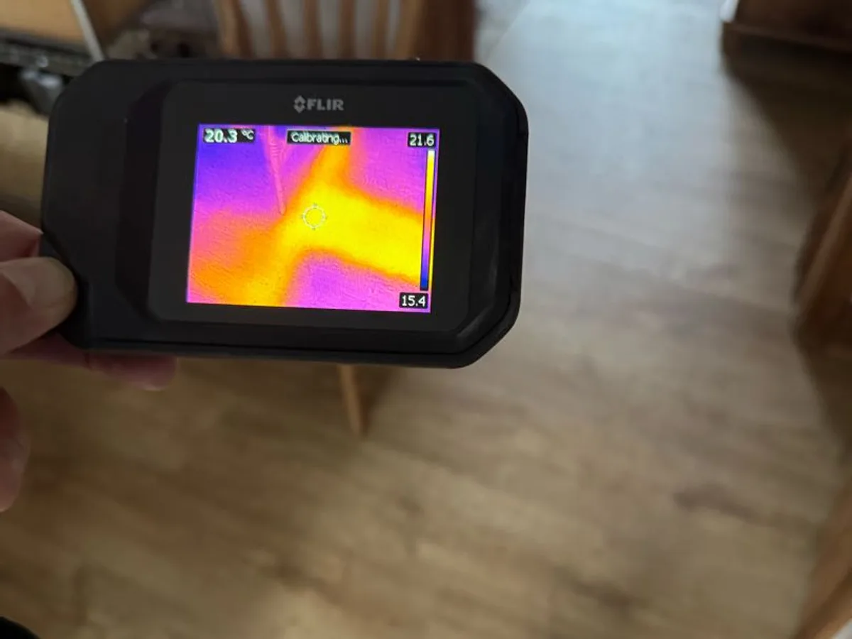thermal imaging camera showing pipe routes on living room floor during leak detection