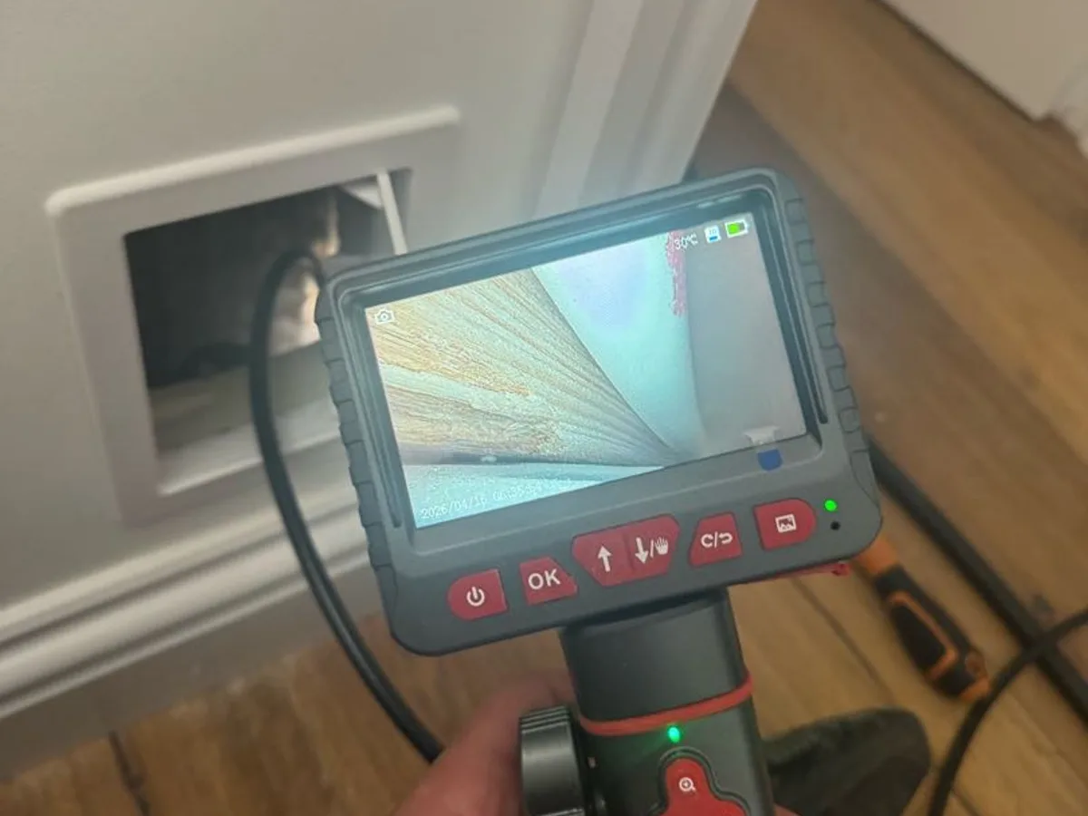 borescope camera inserted into wall access hole in lounge during leak detection survey