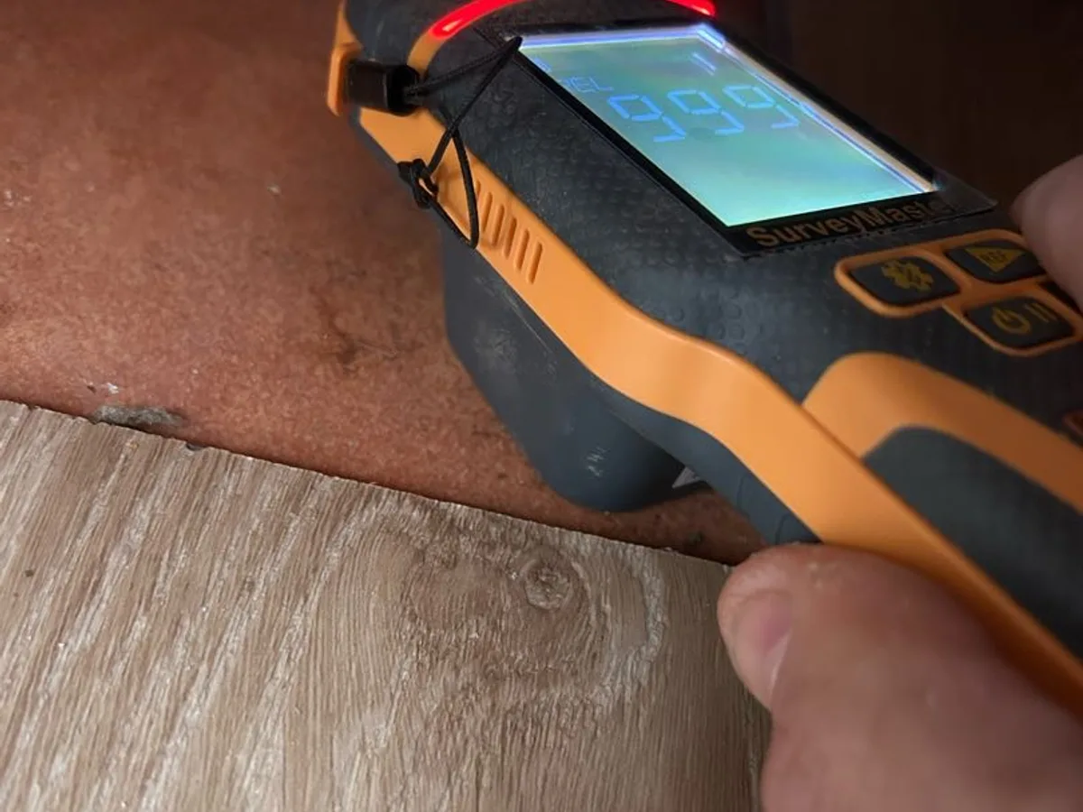 damp meter reading at maximum on kitchen vinyl floor during leak detection survey