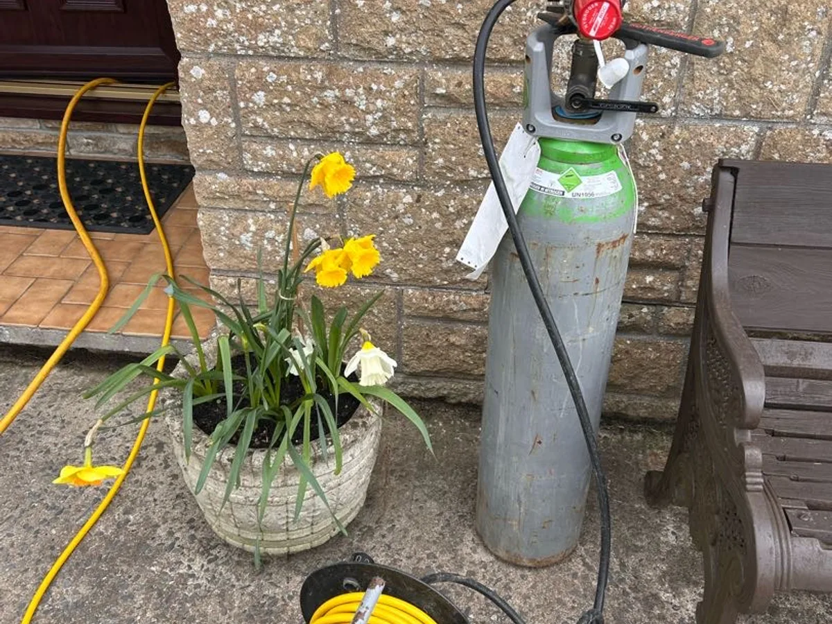 tracer gas cylinder with regulator connected outside front door during leak detection