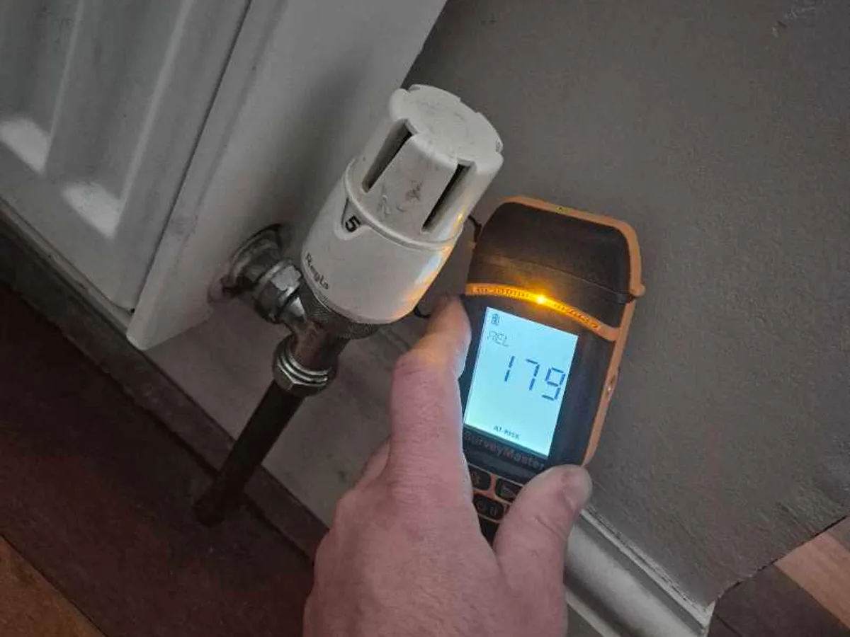 tracer gas detector held at dining room radiator valve showing elevated reading during leak detection