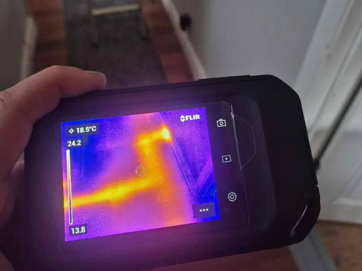 thermal imaging camera screen showing heating pipework beneath hallway floor during leak detection