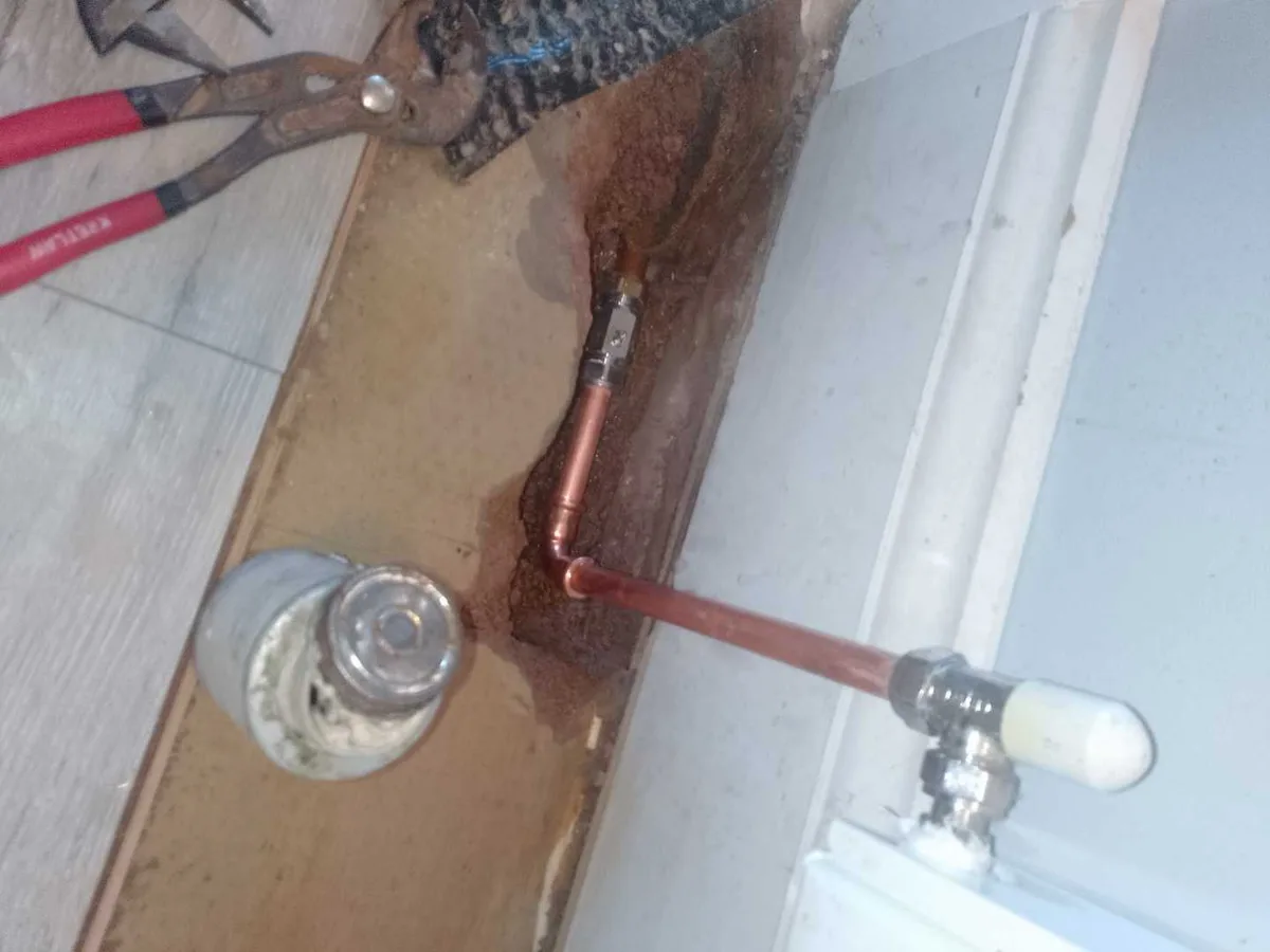 new copper pipe section with press-fit elbow and compression coupling repair completed beneath hallway floor