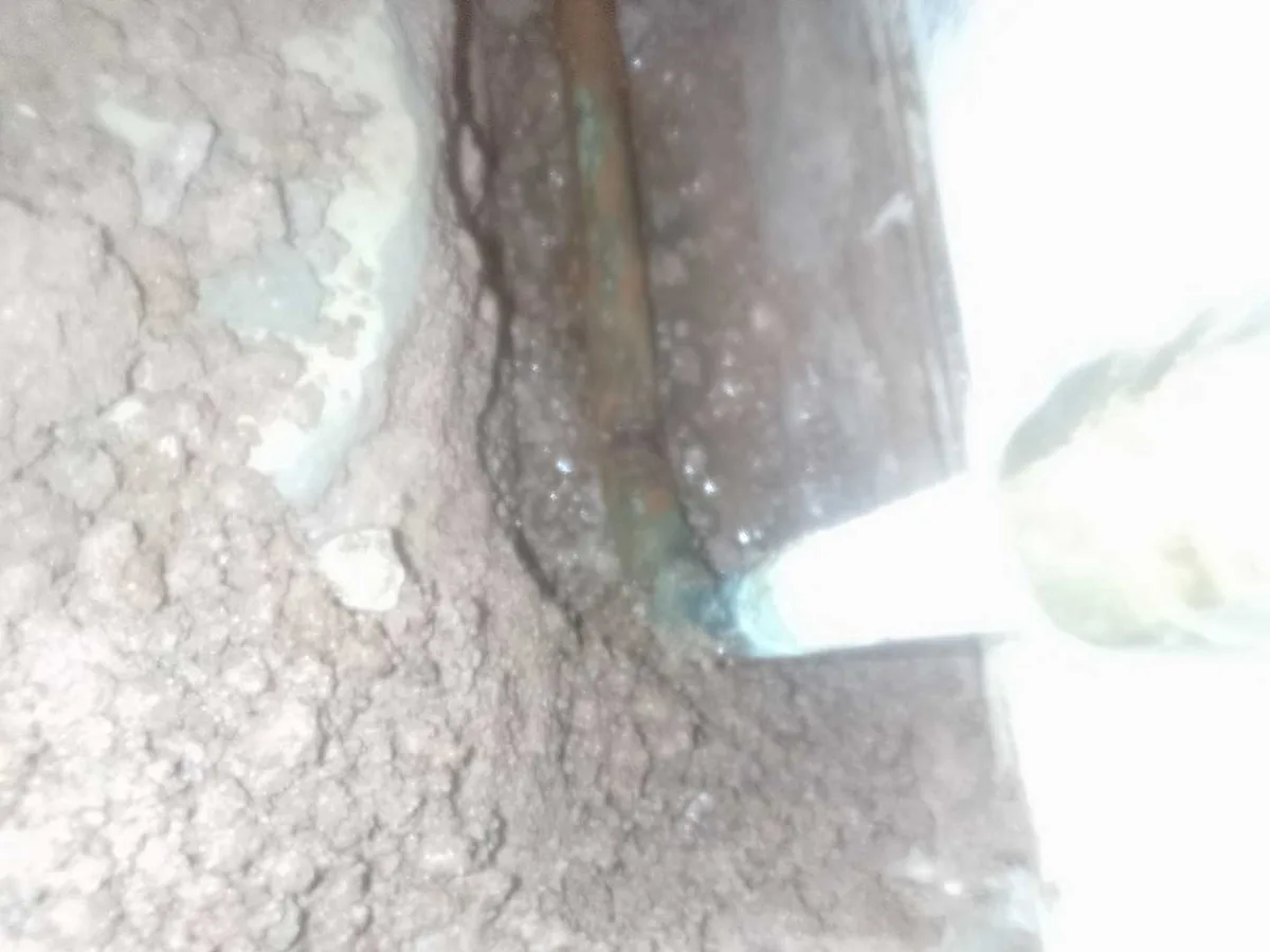 fault exposed at perforated copper heating pipe excavated beneath hallway concrete floor