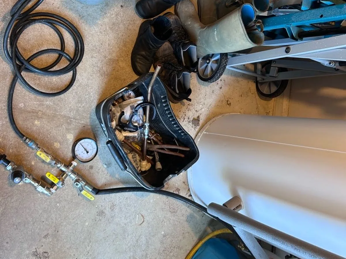 tracer gas cylinder, hoses and pressure gauge laid out during leak detection investigation