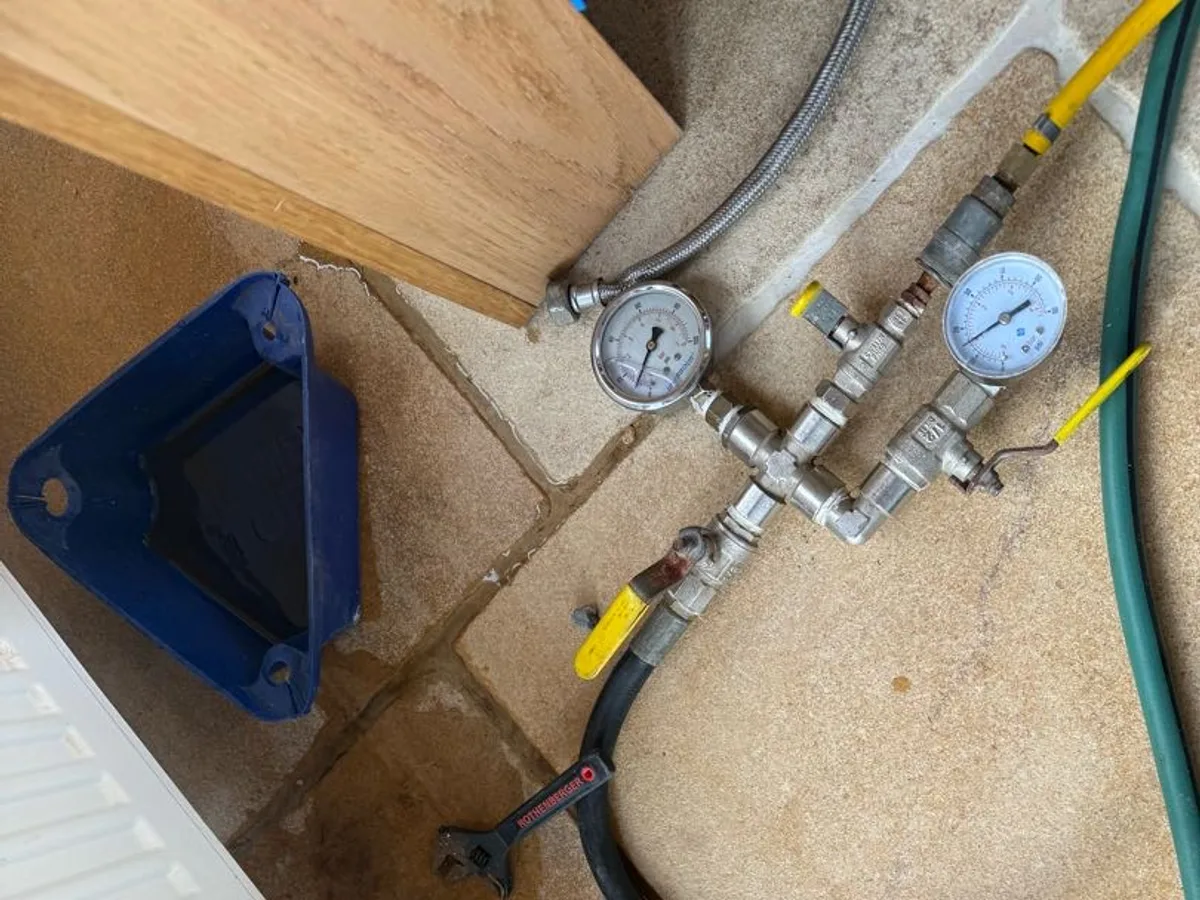 dual-gauge pressure testing rig connected to heating system in use during investigation