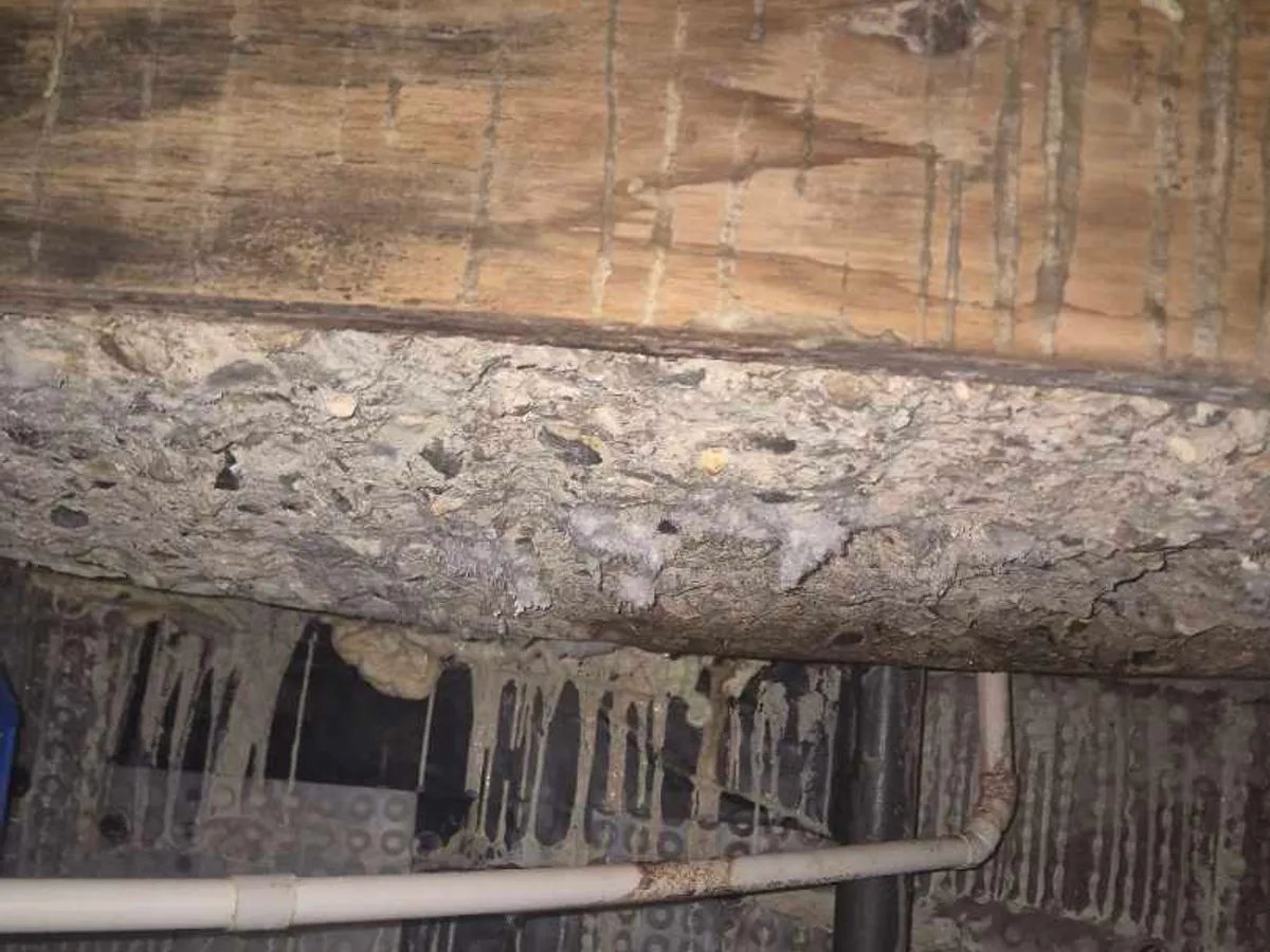 water-stained basement ceiling with mineral deposits and active dripping before works started