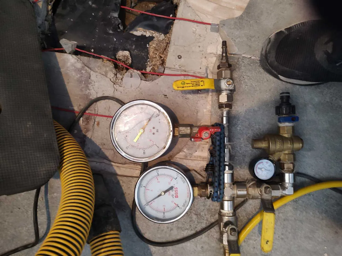 dual pressure test gauges connected to pipework during leak detection investigation