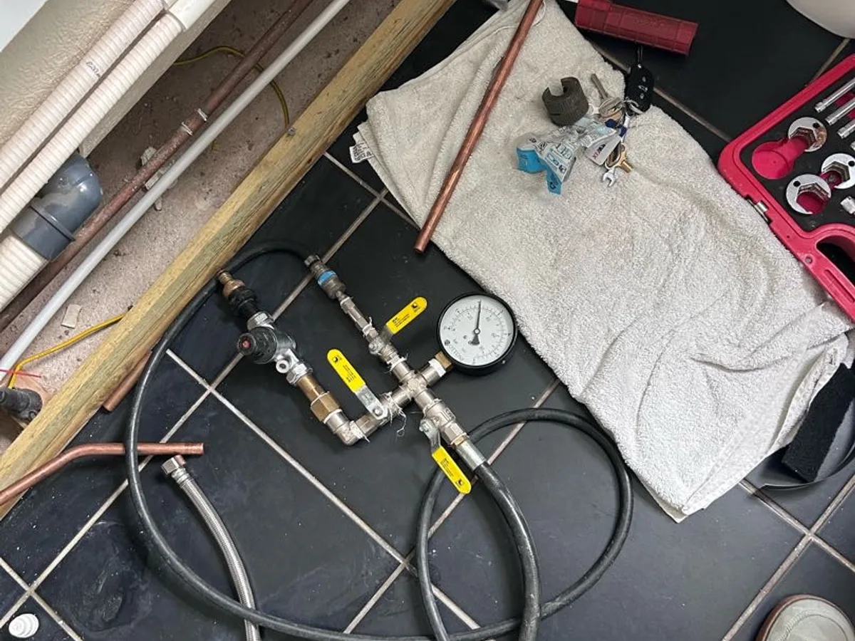 old hot water pipework capped off under bath panel as repair completed