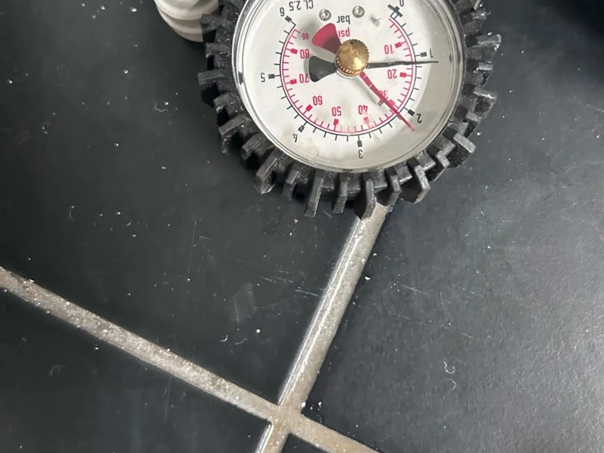 pressure test gauge connected to hot water pipework during leak detection