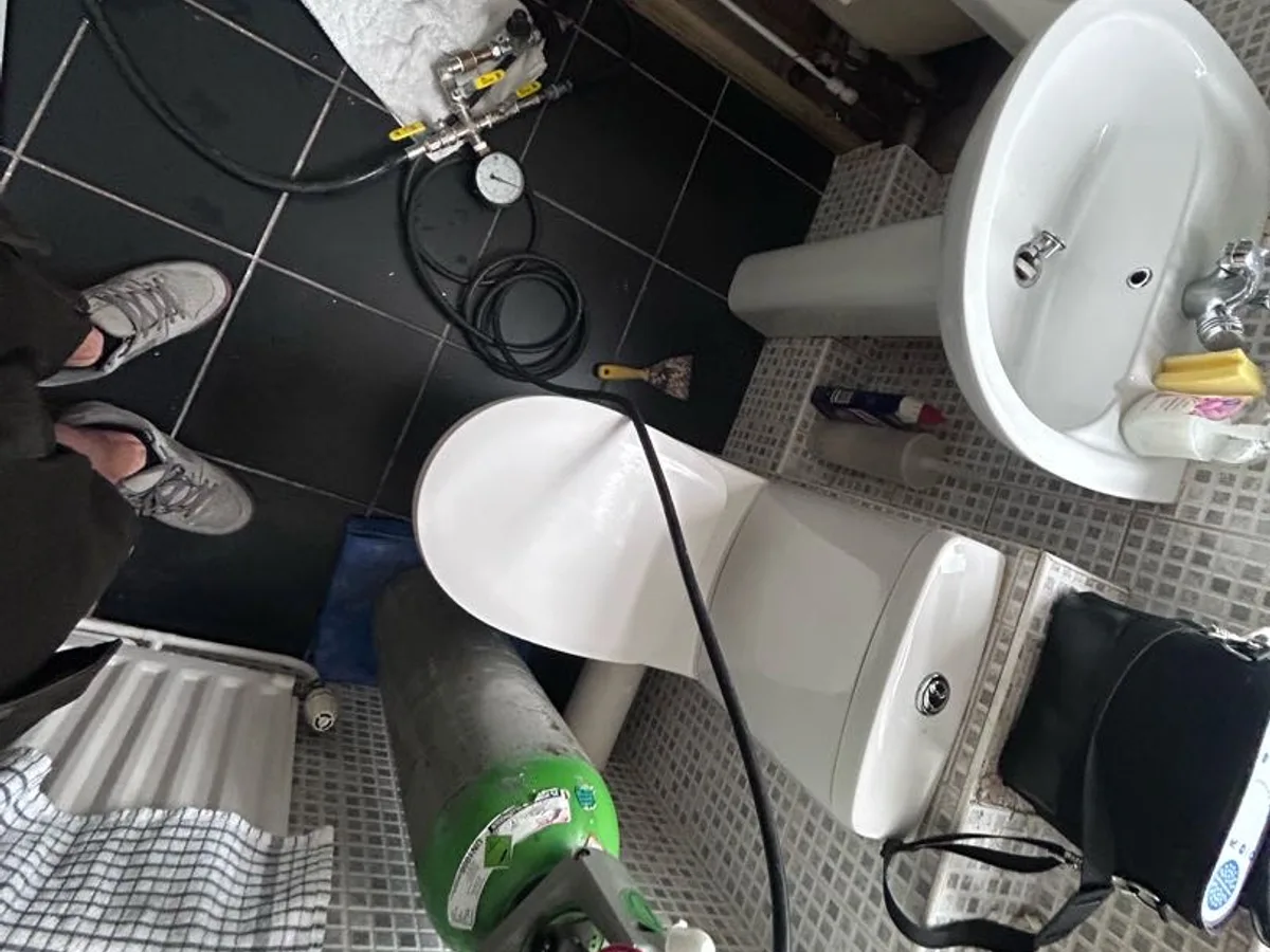 tracer gas cylinder connected to bathroom pipework during leak detection survey