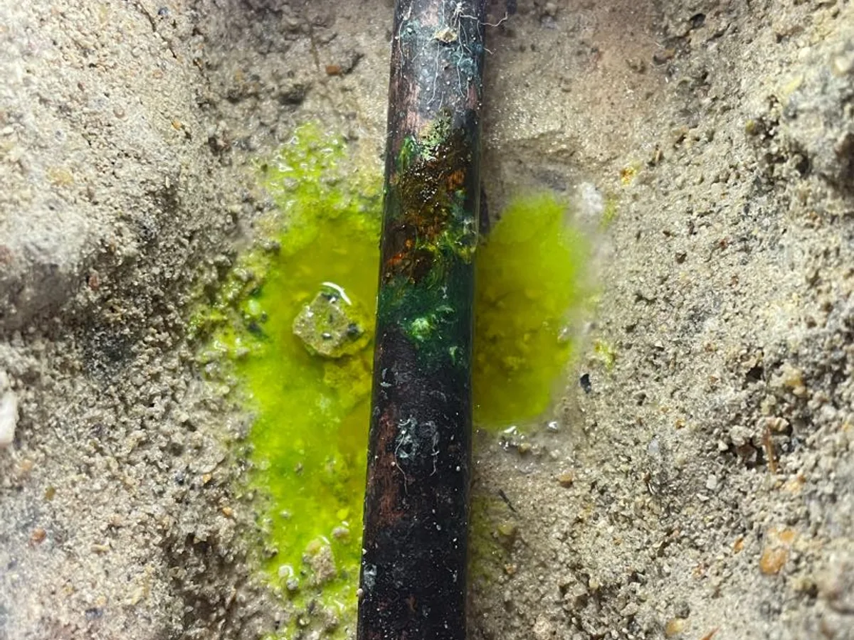 fault identified at pinhole in corroded copper pipe with fluorescent dye confirming leak point — leak located at