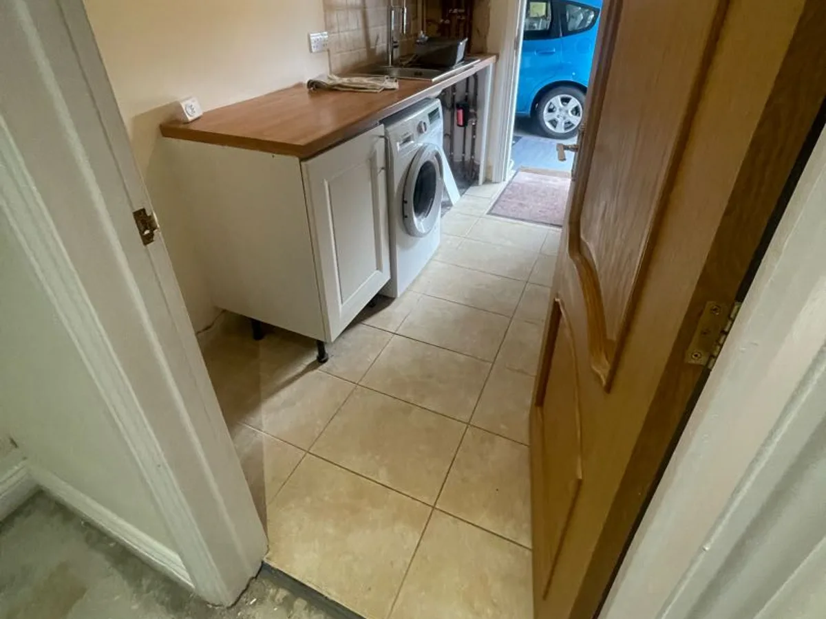 utility room with combination boiler and tiled floor before leak detection works started