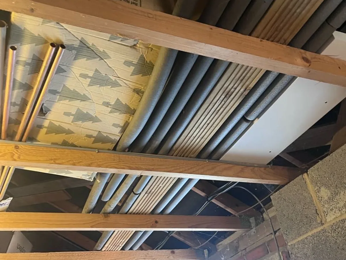 rerouted hot water pipe running through garage roof space as repair completed