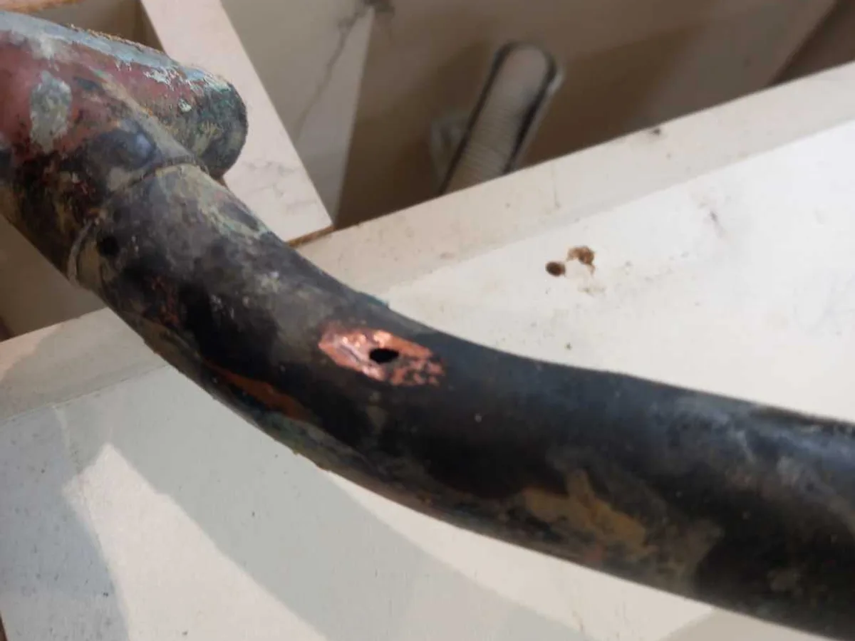 fault identified at pinhole corrosion perforation in heavily corroded 22mm copper pipe — leak located at