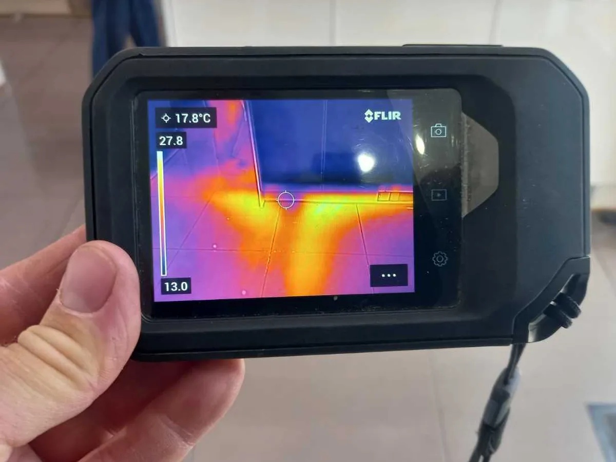 thermal imaging camera screen showing hot water leak pattern beneath kitchen floor during investigation — during leak detection