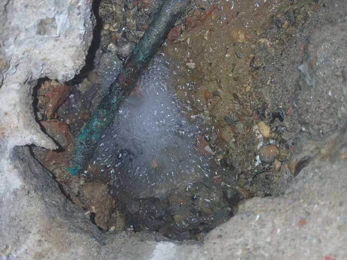fault identified at pinhole corrosion on 15mm copper pipe removed from hallway floor — leak located at