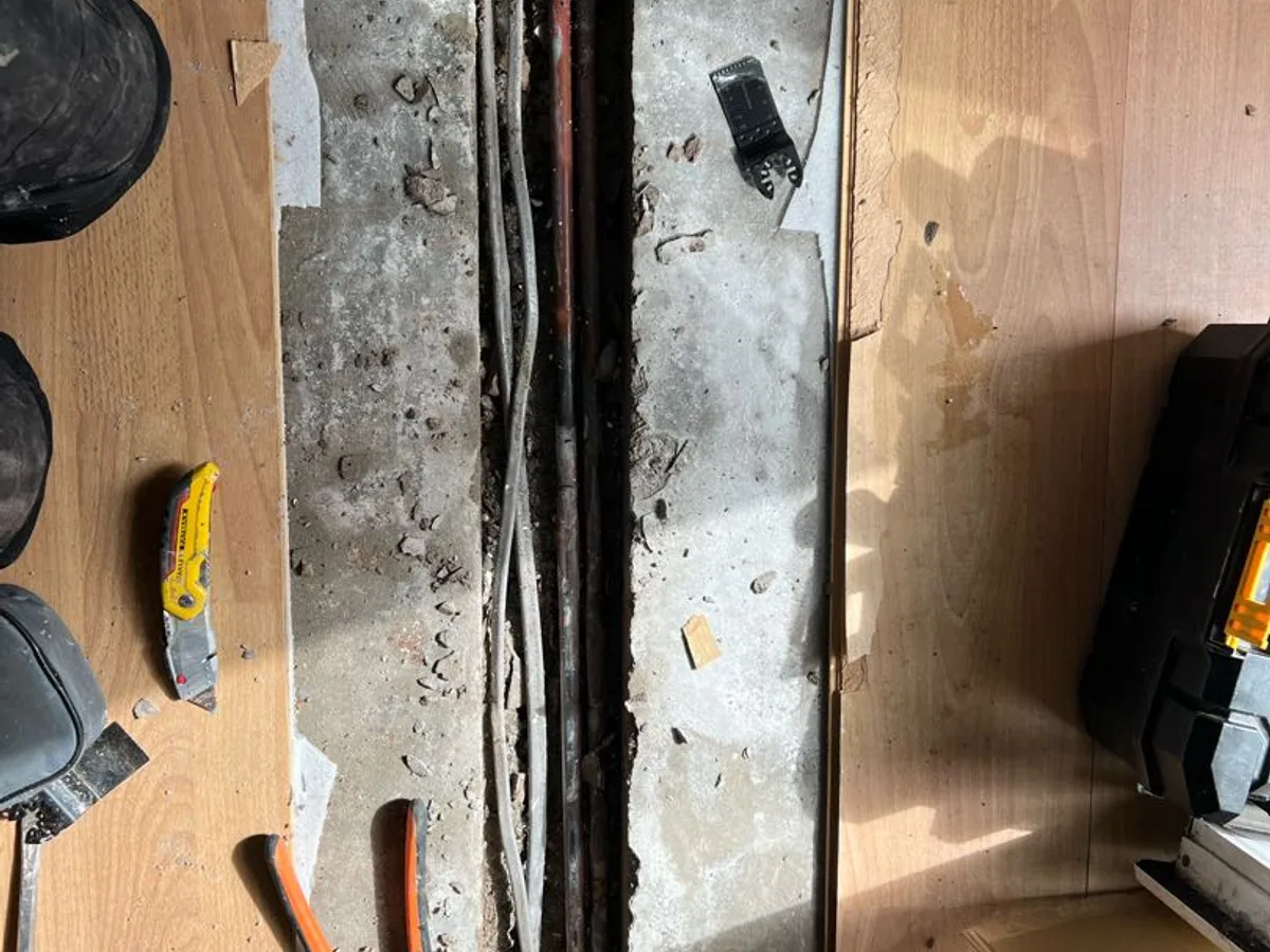 leak exposed at buried copper pipework in concrete floor channel beneath kitchen laminate — leak located at