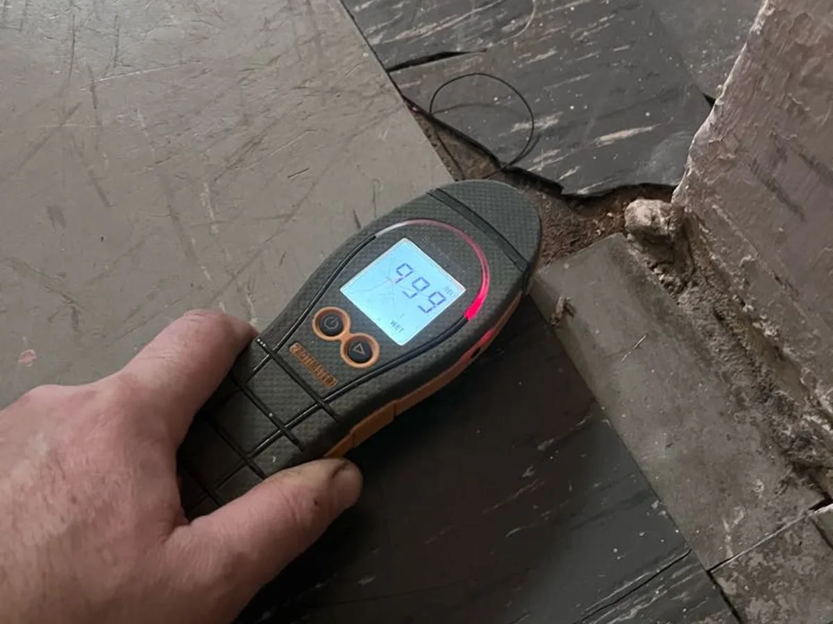 damp meter reading 99.9 at floor edge during leak detection investigation