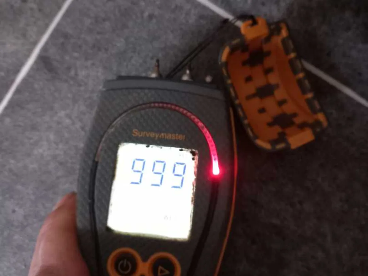 damp meter reading 999 on kitchen floor tiles during leak detection survey