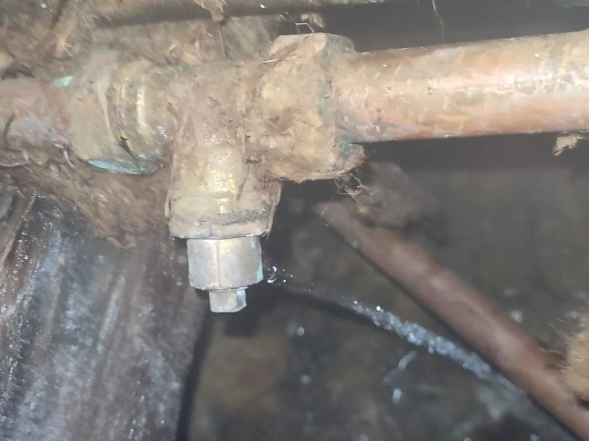 leak located at failed compression fitting on 22mm copper hot water pipe beneath hall floorboards