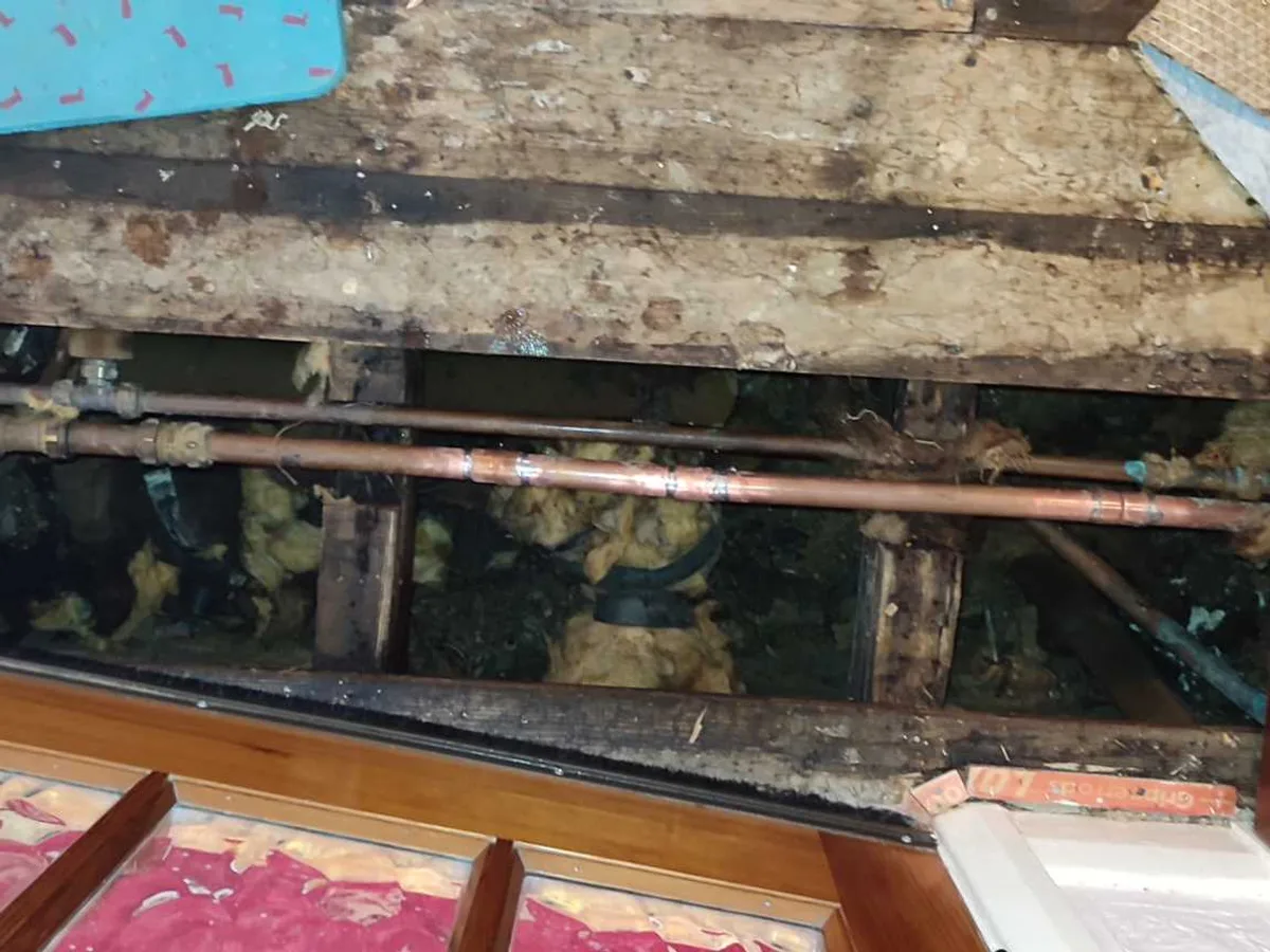 new 22mm copper pipe with new-to-old couplings installed beneath hall floorboards as repair completed