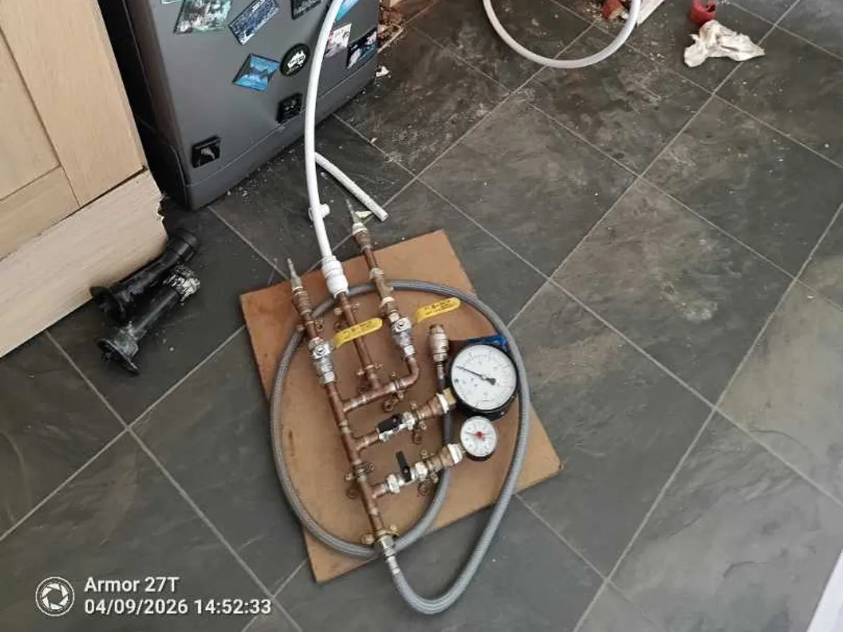 pressure test rig with gauge connected on kitchen floor during leak detection