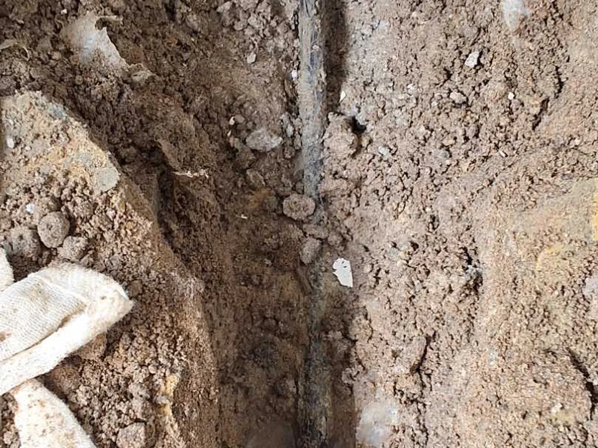 leak located at corroded 15mm copper hot water pipe exposed in excavated hallway floor