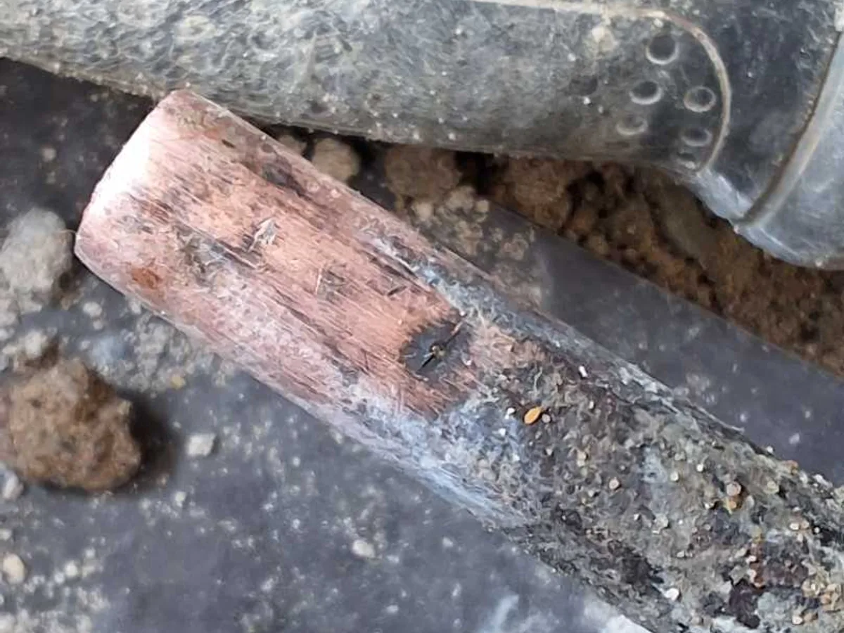 leak located at pinholed and corroded section of 15mm copper pipe removed from hallway floor